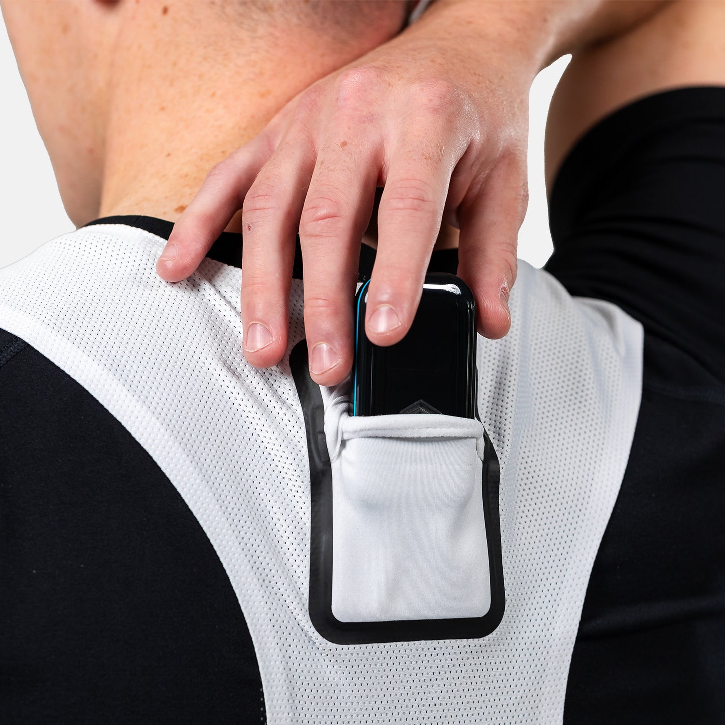 Close-up of a hand inserting a GPS pod into the white STATSports vest pocket