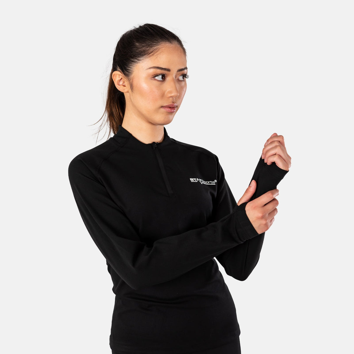 Woman adjusting the sleeve cuff of the STATSports Women's Performance Drill Top